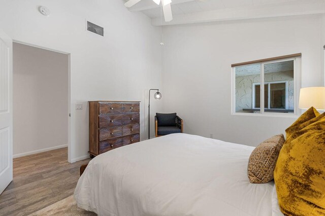 bedroom with ceiling fan, light hardwood / wood-style flooring, and lofted ceiling with beams