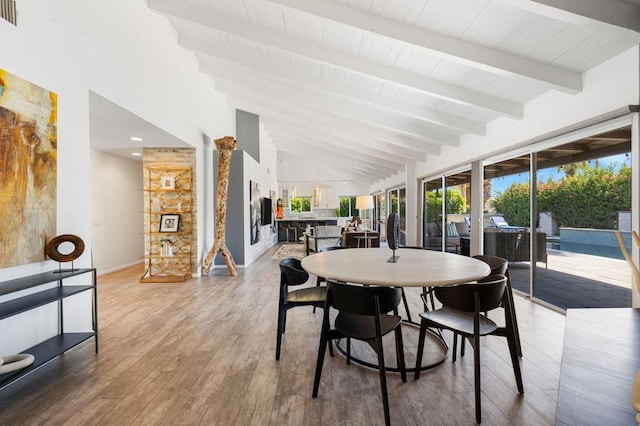 dining room featuring high vaulted ceiling, wood-type flooring, and beam ceiling