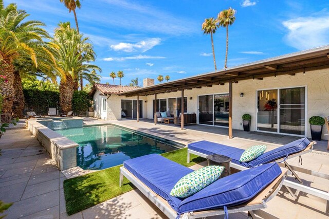 view of pool featuring a patio area and an in ground hot tub