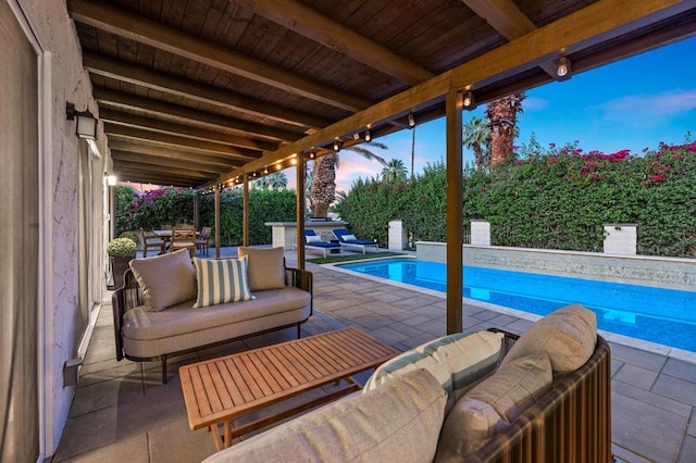 patio terrace at dusk with exterior kitchen and outdoor lounge area