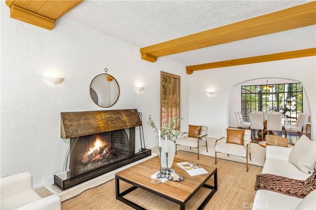 living room with beam ceiling and a textured ceiling