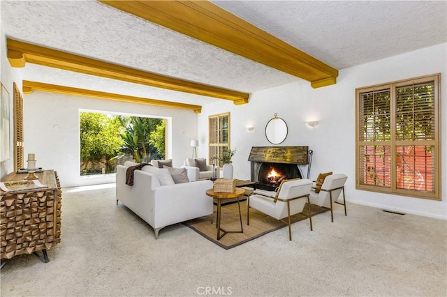 living room featuring beamed ceiling, light carpet, and a textured ceiling