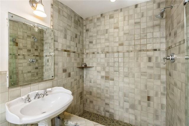 bathroom with backsplash, sink, tile walls, and a tile shower