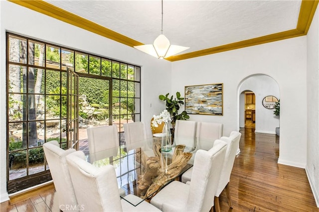 dining space with ornamental molding and dark hardwood / wood-style flooring