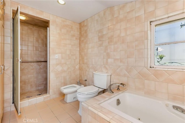 bathroom with independent shower and bath, tile walls, toilet, a bidet, and tile patterned floors