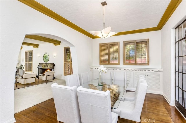 dining room featuring dark hardwood / wood-style flooring, ornamental molding, and a textured ceiling