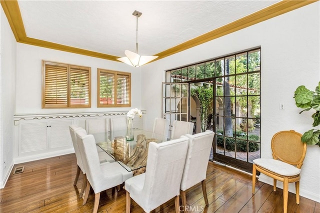 dining area with dark hardwood / wood-style flooring and ornamental molding