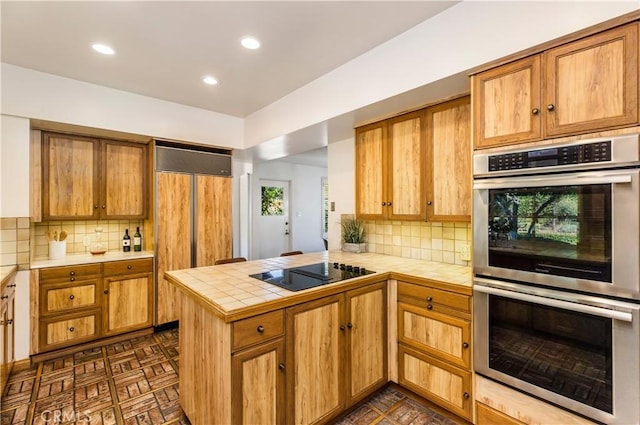 kitchen featuring black electric cooktop, tasteful backsplash, kitchen peninsula, and stainless steel double oven