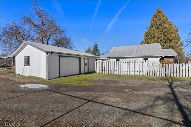 exterior space with a garage and an outbuilding