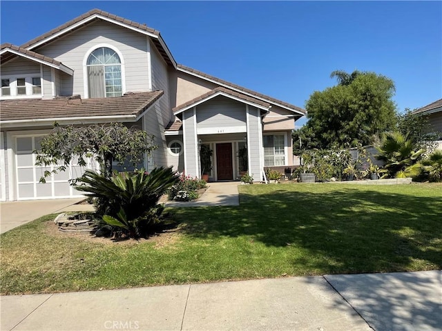 view of front of home with a front yard and a garage