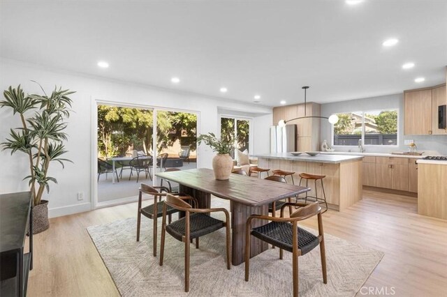 dining room with light wood-type flooring and sink