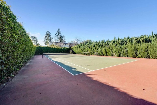 view of tennis court with basketball hoop