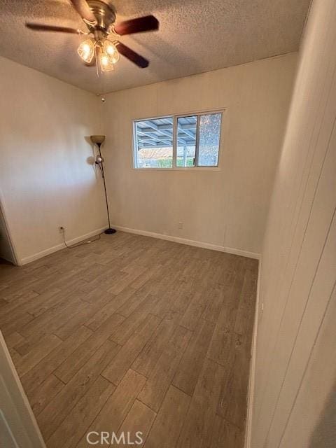 unfurnished room featuring ceiling fan, wood-type flooring, and a textured ceiling