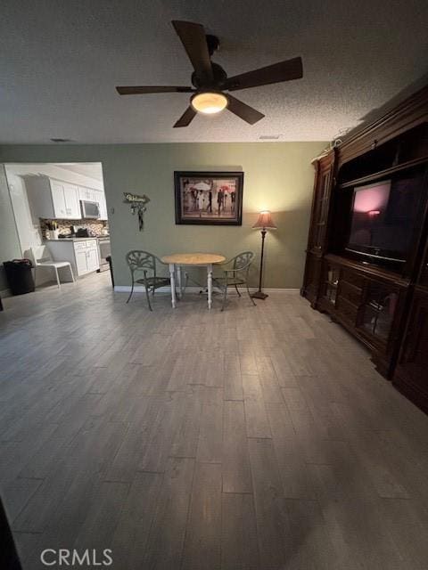 living room featuring ceiling fan and wood-type flooring