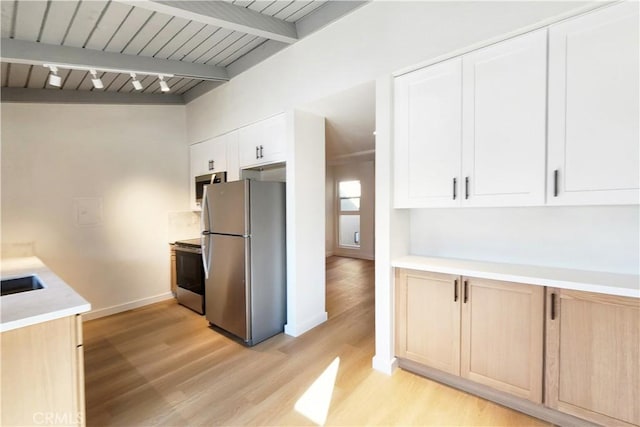 kitchen featuring light hardwood / wood-style floors, beamed ceiling, white cabinetry, light brown cabinets, and stainless steel appliances