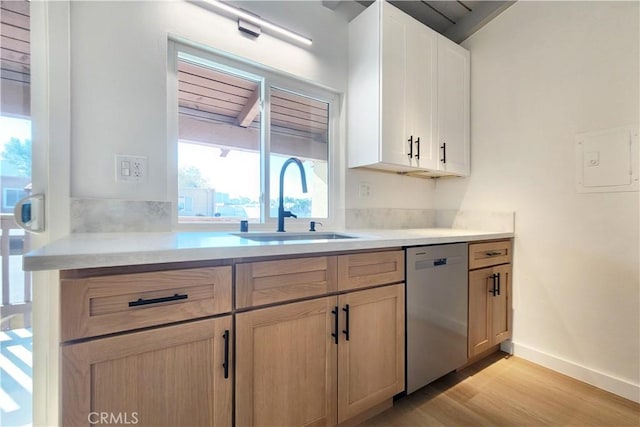 kitchen featuring light brown cabinets, light wood-type flooring, stainless steel dishwasher, white cabinets, and sink