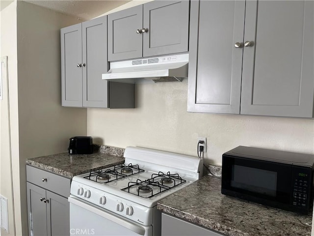 kitchen featuring white range with gas stovetop and gray cabinetry