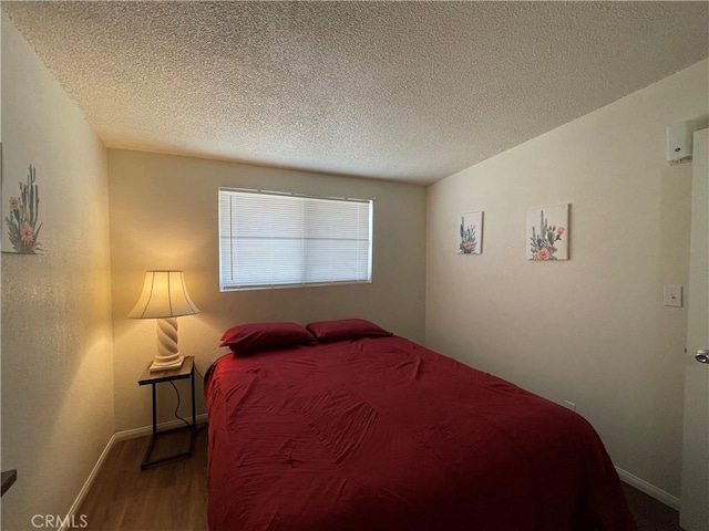 bedroom with wood-type flooring and a textured ceiling