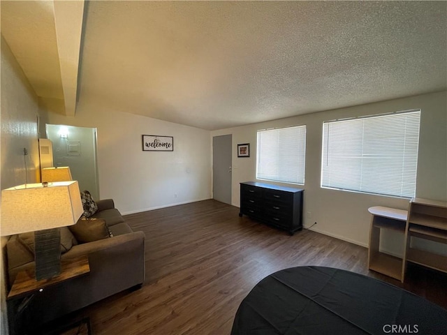 living room with a textured ceiling, hardwood / wood-style flooring, and lofted ceiling with beams