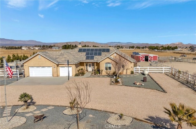 view of front of house featuring a mountain view, solar panels, and a garage