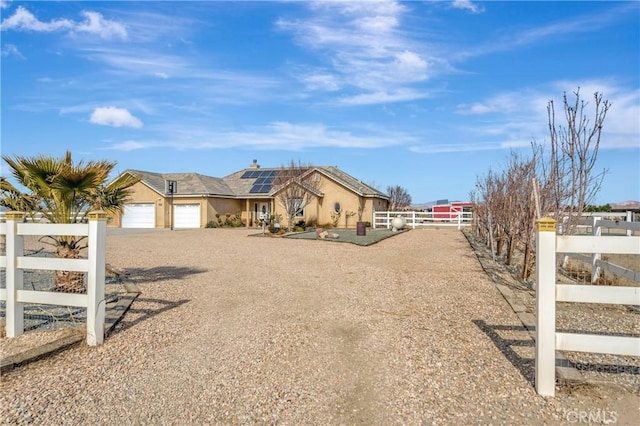 view of front of property with a garage and solar panels