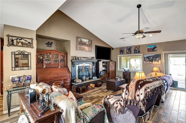 living room with ceiling fan, a wealth of natural light, and lofted ceiling