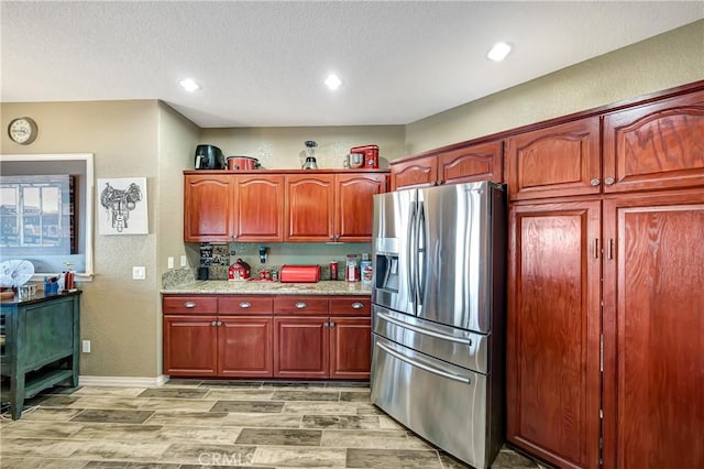 kitchen featuring wood-type flooring and stainless steel fridge