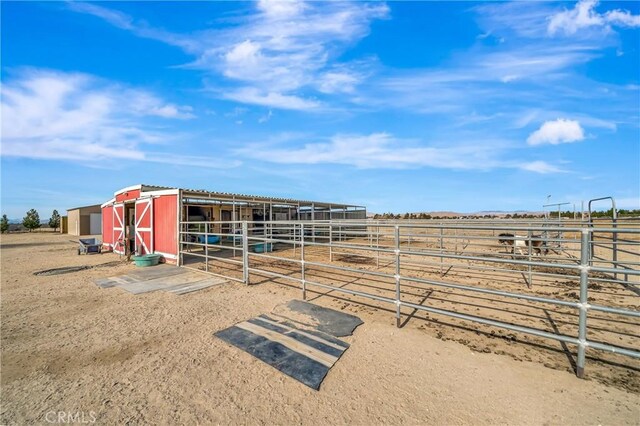 view of horse barn with a rural view