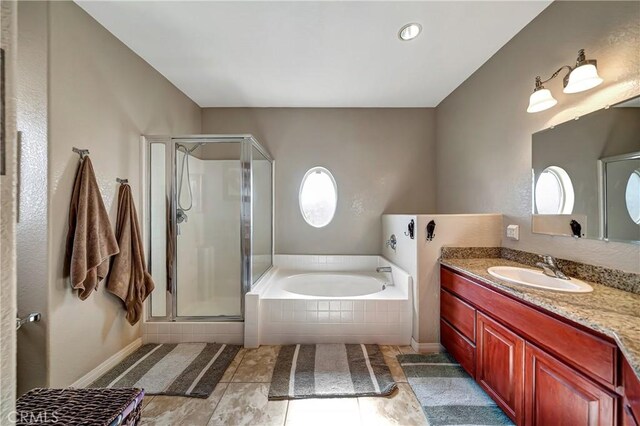 bathroom featuring tile patterned flooring, vanity, and shower with separate bathtub