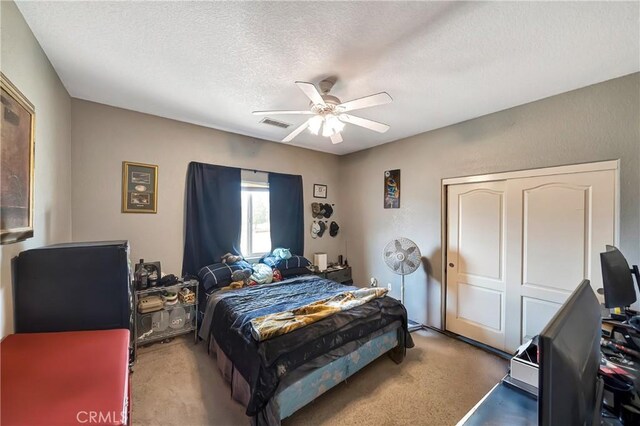 bedroom featuring ceiling fan, a closet, and a textured ceiling