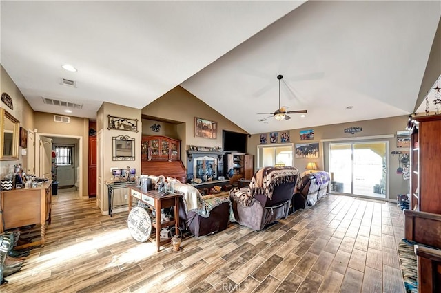 living room featuring ceiling fan and lofted ceiling