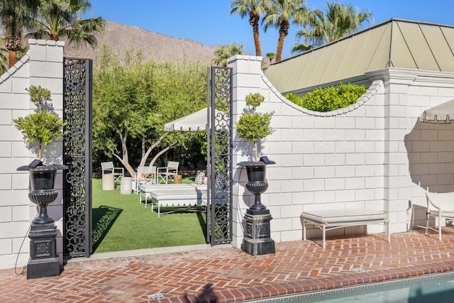 view of gate featuring a lawn and a mountain view