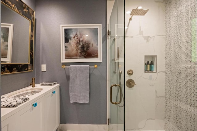 bathroom featuring a shower with shower door and vanity