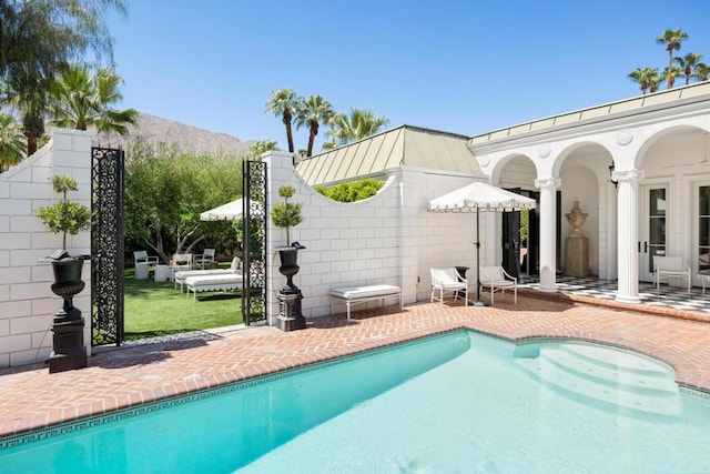 view of pool featuring a mountain view and a patio