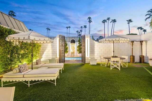 yard at dusk with a fenced in pool