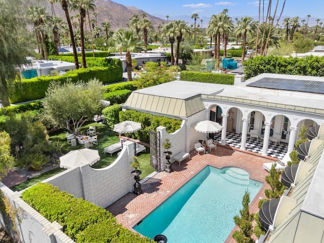 view of swimming pool featuring a mountain view and a patio