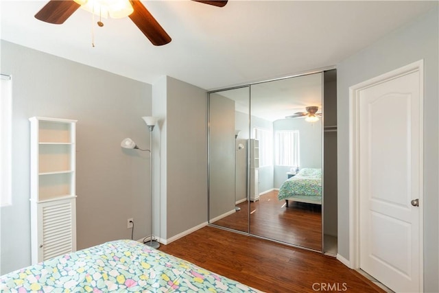 bedroom featuring dark wood-type flooring, ceiling fan, and a closet