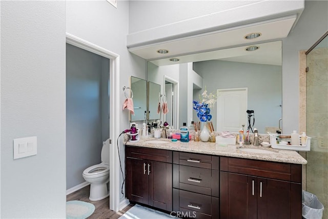 bathroom with a shower, wood-type flooring, toilet, and vanity