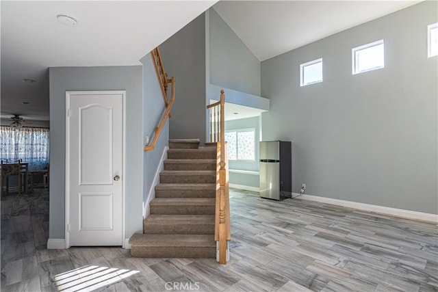 stairway featuring ceiling fan, hardwood / wood-style flooring, and a healthy amount of sunlight