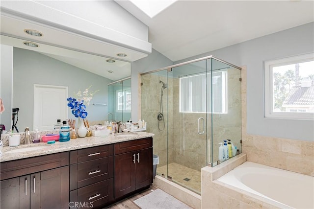 bathroom featuring vaulted ceiling, separate shower and tub, and vanity