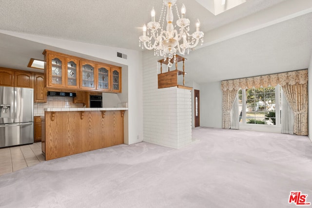 kitchen featuring vaulted ceiling, light carpet, kitchen peninsula, black oven, and stainless steel fridge