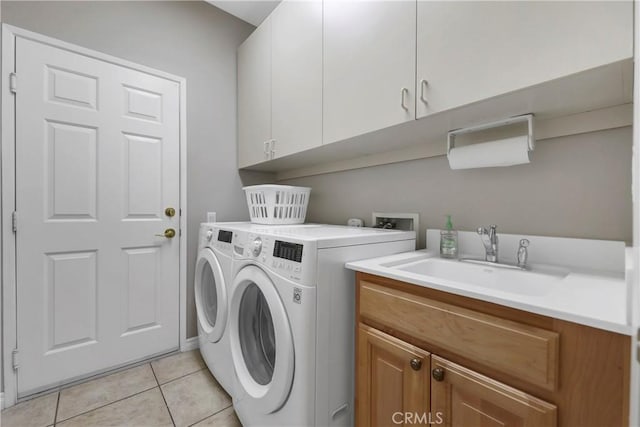 washroom with cabinets, light tile patterned flooring, independent washer and dryer, and sink