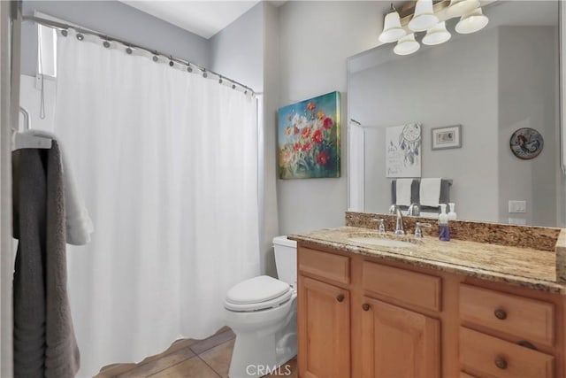 bathroom with toilet, vanity, and tile patterned flooring