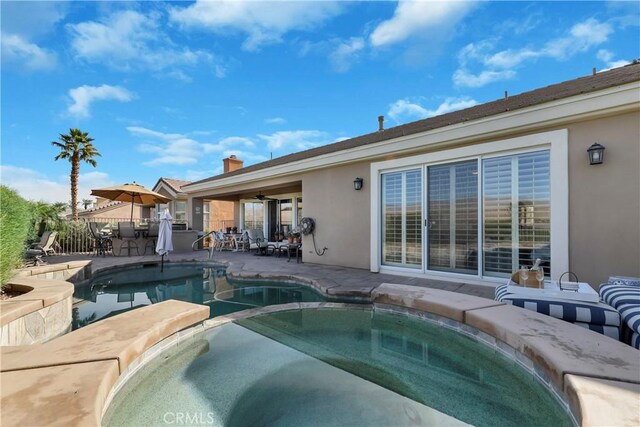 view of swimming pool featuring ceiling fan, an in ground hot tub, and a patio