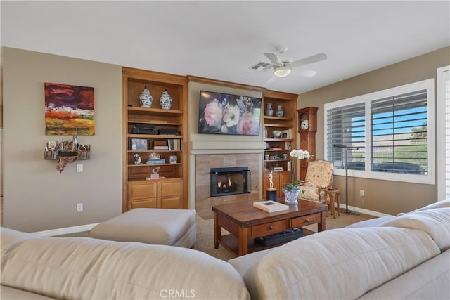 living room featuring ceiling fan, carpet, and a tiled fireplace