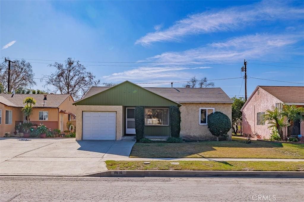 view of front of home with a front yard and a garage