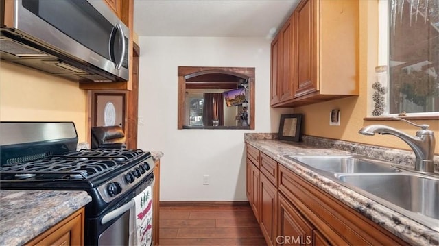 kitchen featuring sink, dark stone countertops, and stainless steel appliances