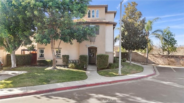 mediterranean / spanish house with a front lawn