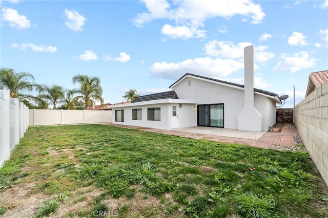 back of property with a patio area and a lawn