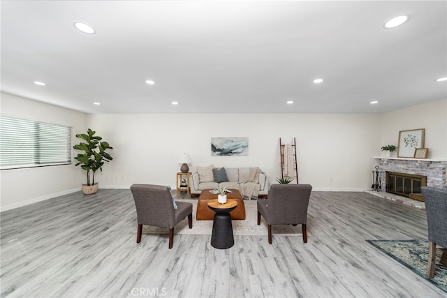 living room featuring light wood-type flooring and a fireplace